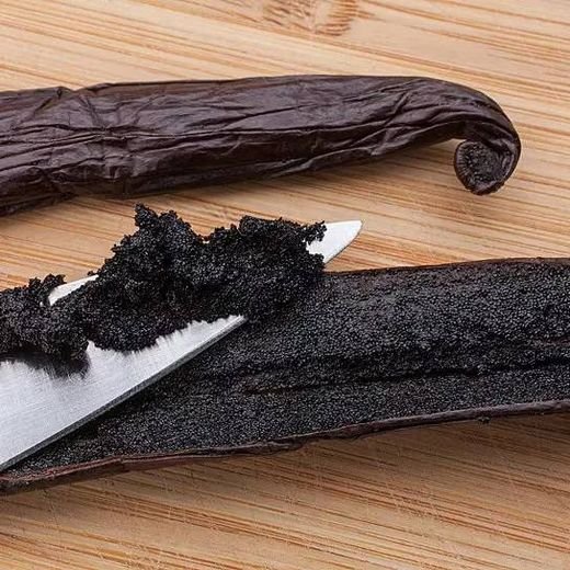Split Grade A Planifolia vanilla bean showing dense black seed paste
